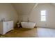 Bright bathroom with standalone tub, white cabinets, and dormer window at 5752 River Rd, Waldron, IN 46182