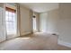 Spacious bedroom with neutral carpet, two windows, and a white door leading to the hallway at 5752 River Rd, Waldron, IN 46182