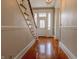 Inviting entryway featuring hardwood floors and a classic staircase with a charming front door with stained glass at 5752 River Rd, Waldron, IN 46182