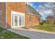Brick home exterior featuring a doorway with double doors and concrete path at 5752 River Rd, Waldron, IN 46182