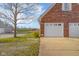 Side view of brick home with garage door and yard area at 5752 River Rd, Waldron, IN 46182
