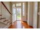 Inviting foyer with hardwood floors, a staircase, and a view of the outdoors through a glass-paneled front door at 5752 River Rd, Waldron, IN 46182