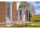 Charming front porch with a white rocking chair, decorative accents, and a brick facade at 5752 River Rd, Waldron, IN 46182