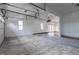 Spacious garage interior featuring concrete flooring, multiple windows, and a door leading into the house at 5752 River Rd, Waldron, IN 46182