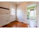 Hallway leading to a bathroom with wainscoting, and hardwood floors at 5752 River Rd, Waldron, IN 46182