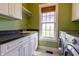 Functional laundry room with white cabinets, black counters, and a front load washer and dryer at 5752 River Rd, Waldron, IN 46182