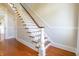 Classic staircase featuring hardwood steps, white risers, and railing detail at 5752 River Rd, Waldron, IN 46182