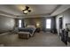 Large bedroom with tray ceiling, ceiling fans, a bed, and seating area at 5810 Grand Ave, Plainfield, IN 46168