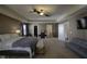 Large primary bedroom with seating area, tray ceiling, and modern ceiling fans at 5810 Grand Ave, Plainfield, IN 46168