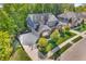 Aerial view of a home with a well-manicured lawn, mature trees, and a three car garage at 6504 W May Apple Dr, McCordsville, IN 46055