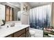 Bathroom featuring a vanity with dark wood cabinets, a large mirror, and a shower with a nature-themed curtain at 6504 W May Apple Dr, McCordsville, IN 46055
