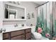 Bathroom featuring a vanity with dark wood cabinets, a large mirror, and a shower with a cactus-themed curtain at 6504 W May Apple Dr, McCordsville, IN 46055