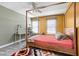 Bedroom featuring wood-framed four-poster bed, complemented by yellow walls and a vibrant area rug at 6504 W May Apple Dr, McCordsville, IN 46055