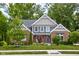 Charming two-story brick home with lush landscaping and inviting front porch at 6504 W May Apple Dr, McCordsville, IN 46055