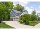 Side view of a brick home featuring a three-car garage and landscaped yard at 6504 W May Apple Dr, McCordsville, IN 46055
