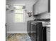 Bright laundry room with gray cabinets, modern washer and dryer, and a charming decorative touch at 6504 W May Apple Dr, McCordsville, IN 46055