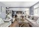 Open-concept living room with hardwood floors, a plush sofa, and a view of the modern kitchen at 6504 W May Apple Dr, McCordsville, IN 46055
