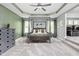 Spacious main bedroom with a four-poster bed, tray ceiling, and connecting sitting area at 6504 W May Apple Dr, McCordsville, IN 46055