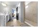 Bright bathroom featuring a dual sink vanity, tile flooring, and a glass-enclosed shower with tiled walls at 6705 Park Grove Blvd, Whitestown, IN 46075