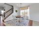 Dining room with a wood table, seating for four, a decorative wreath, and a staircase leading to the second floor at 6705 Park Grove Blvd, Whitestown, IN 46075