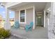 Charming front porch with columns, a sitting area with stylish Adirondack chairs and a decorative, painted green door at 6705 Park Grove Blvd, Whitestown, IN 46075