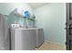 Practical laundry room equipped with a washer, a dryer, and shelving, enhancing convenience for household chores at 6705 Park Grove Blvd, Whitestown, IN 46075