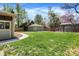 Lush backyard featuring a well-maintained lawn and a walkway to the detached garage at 828 Woodruff Place Middle Dr, Indianapolis, IN 46201
