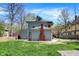 A spacious backyard with lush grass, mature trees and a brick chimney at 828 Woodruff Place Middle Dr, Indianapolis, IN 46201