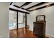Hallway features beamed ceilings, wood floors, and a vintage dresser and mirror at 828 Woodruff Place Middle Dr, Indianapolis, IN 46201