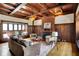 Cozy living room featuring wood paneling, a brick fireplace, and comfortable seating at 828 Woodruff Place Middle Dr, Indianapolis, IN 46201