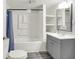 Well-lit bathroom featuring tub, shower, grey vanity with sink and mirror, plus handy storage shelves at 952 N Concord St, Indianapolis, IN 46222