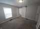 Cozy bedroom with carpet, barn door to bath, neutral walls, and bright window at 952 N Concord St, Indianapolis, IN 46222
