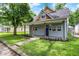 Charming home featuring a cozy front porch, blue door, and a well-maintained lawn at 952 N Concord St, Indianapolis, IN 46222