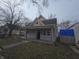 Traditional one-story home with front porch, gray siding and mature trees at 952 N Concord St, Indianapolis, IN 46222