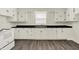 Bright kitchen featuring white cabinets, dark countertops, and gray laminate floors at 952 N Concord St, Indianapolis, IN 46222