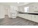 Bright kitchen featuring white cabinets, dark countertops, and gray laminate floors at 952 N Concord St, Indianapolis, IN 46222