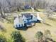 White home featuring a stone patio and expansive lawns in a wooded setting at 10120 Fox Trce, Zionsville, IN 46077