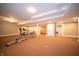 Open-concept basement features workout equipment, lighting, and neutral walls at 10120 Fox Trce, Zionsville, IN 46077
