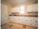 Spacious laundry room featuring ample storage space with upper and lower cabinets with a window view at 10120 Fox Trce, Zionsville, IN 46077
