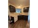 Kitchen features dark wood cabinetry, stainless steel sink, and adjacent living space view at 10419 Dark Star Dr, Indianapolis, IN 46234