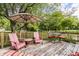 Relaxing back deck featuring patio furniture, a sun umbrella, and surrounding trees at 11710 Prairie Pl, Carmel, IN 46033