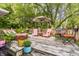 Relaxing back deck featuring patio furniture, colorful potted plants, and surrounding trees at 11710 Prairie Pl, Carmel, IN 46033