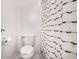 Bright white bathroom featuring a toilet and patterned black-and-white shower curtain at 11710 Prairie Pl, Carmel, IN 46033