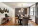 Spacious dining area featuring a dark wood table, plush chairs, and stylish decor with hardwood flooring at 11710 Prairie Pl, Carmel, IN 46033