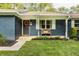 Welcoming entrance with black door, decorative wreath, and a bench, surrounded by flower boxes and landscaping at 11710 Prairie Pl, Carmel, IN 46033