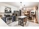 Open-concept kitchen with stainless steel appliances and island seating, flowing into the dining and living areas at 11710 Prairie Pl, Carmel, IN 46033