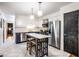 Bright kitchen with white cabinets, stainless steel appliances, island with seating, and stylish pendant lighting at 11710 Prairie Pl, Carmel, IN 46033
