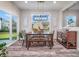 Bright dining room with access to outdoor patio and features wooden table and bench, grey upholstered chairs at 12650 Sunrise Dr, Noblesville, IN 46060