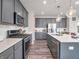 Modern kitchen with stainless appliances, gas range, gray cabinets, quartz countertops, and a spacious island at 12650 Sunrise Dr, Noblesville, IN 46060