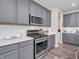 Well-equipped kitchen featuring stainless steel appliances, including a gas range and microwave, and shaker style gray cabinetry at 12650 Sunrise Dr, Noblesville, IN 46060